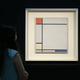 A Sotheby’s employee poses with Mondrian’s 1927 painting ‘Composition with Red, Yellow and Blue’ on display at the auction house in in 2013.